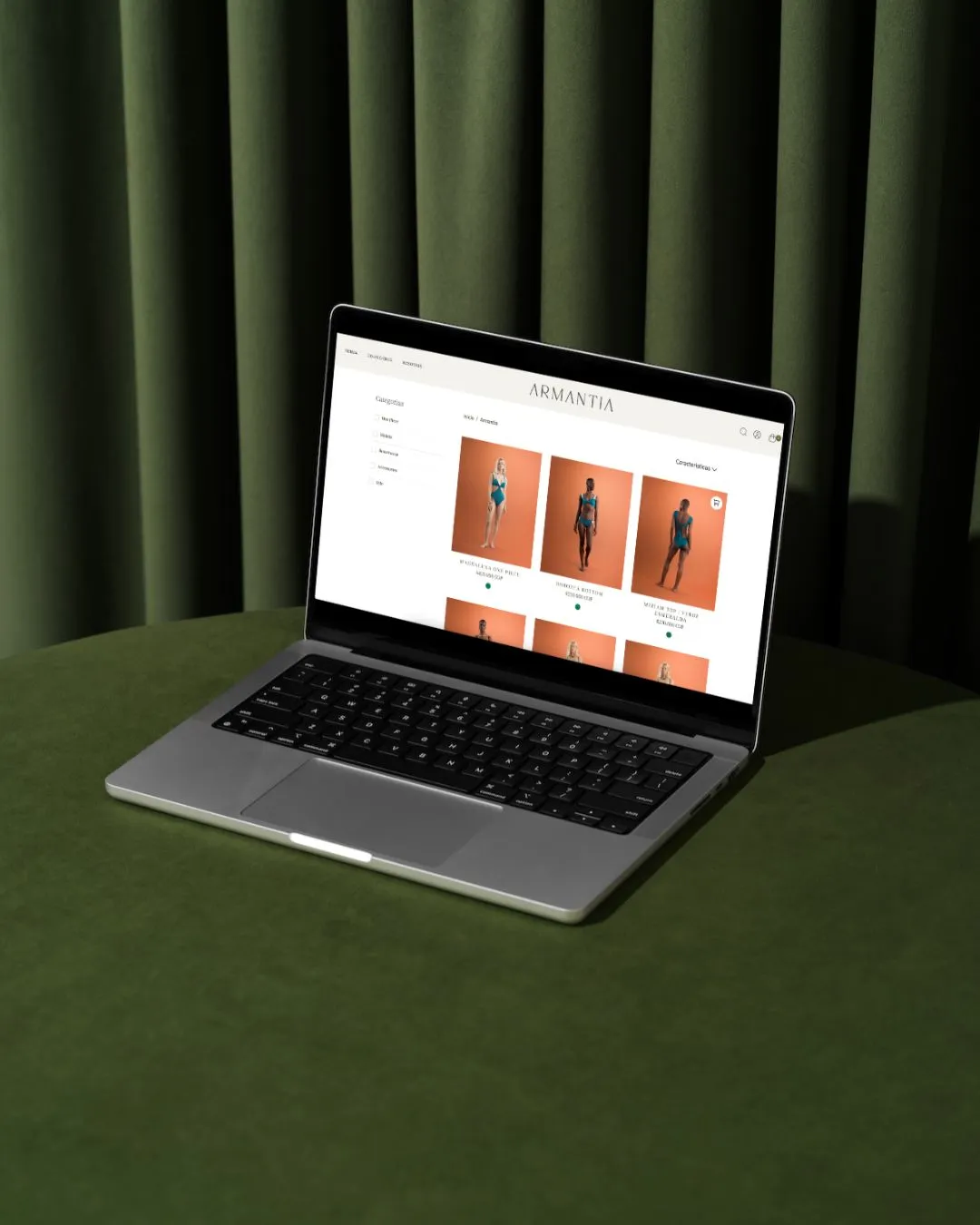 Armantia catalog on a laptop in front of green curtains